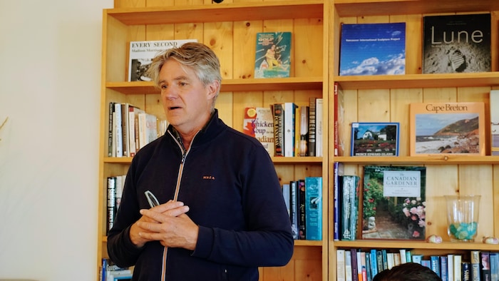 Portrait d,Alexander Reford devant une bibliothèque de l'Espace Métis