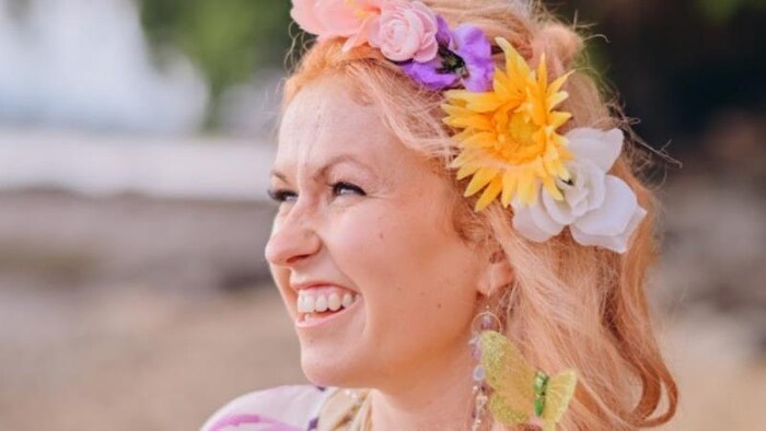 Alexandra Ferron, tout sourire, avec des fleurs dans les cheveux.