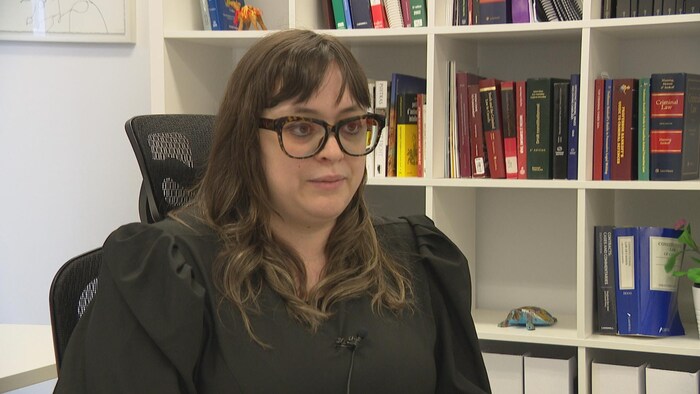 Femme devant bibliothèque dans un bureau