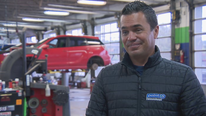 Alexandre Labelle accorde une entrevue à Radio-Canada à l’intérieur d’un garage automobile.