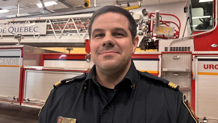 Alexandre Lajoie devant un camion de pompiers.