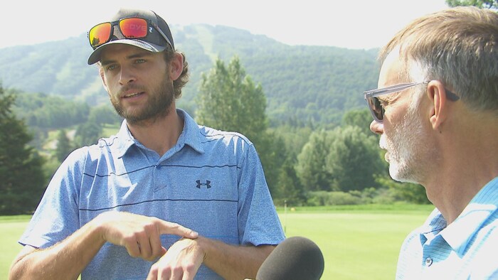Alexandre Ouellet exprime quelque chose en langue des signes. Alain Turpin est à ses côtés.