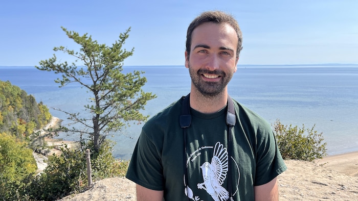 Alexandre Terrigeol, souriant devant l'océan. Il est dans la nature.