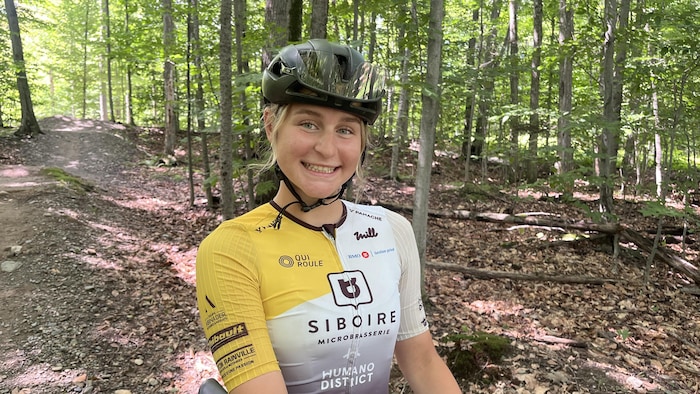 Alexia Harel porte un casque et son maillot de l'équipe Siboire QuiRoule.
