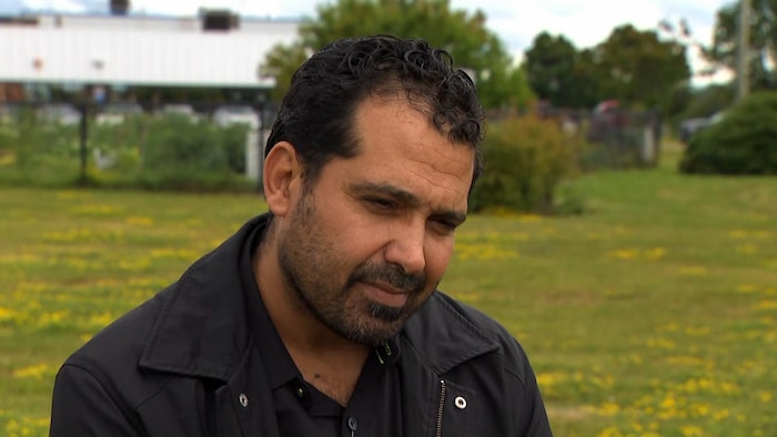 Un homme interviewé à l'extérieur.