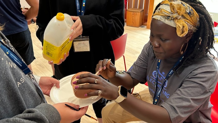 Alice Aol avec un contenant dans les mains. 
