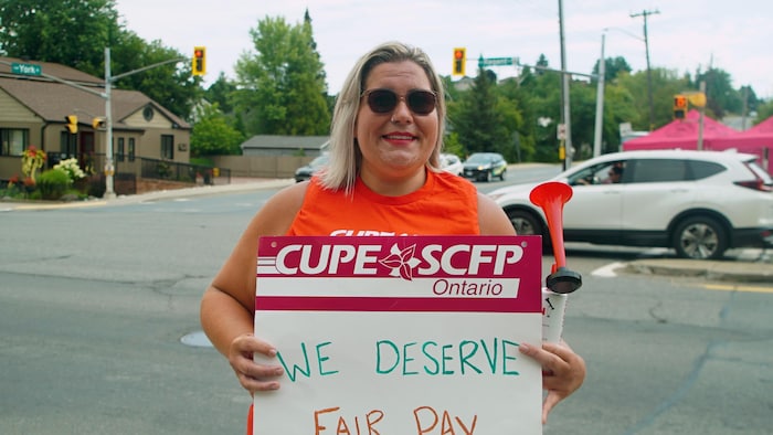 Alicia Lachance, aide-soignante à Extendicare York, tient une pancarte du syndicat. 