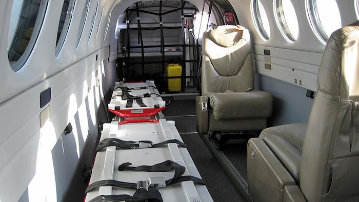 L'intérieur d'un petit avion avec des civières.
