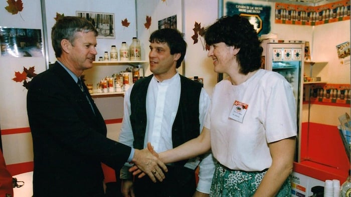 Michèle Bond serre la main du ministre Lyle Vanclief, sous le regard de Sylvain Lalli.  