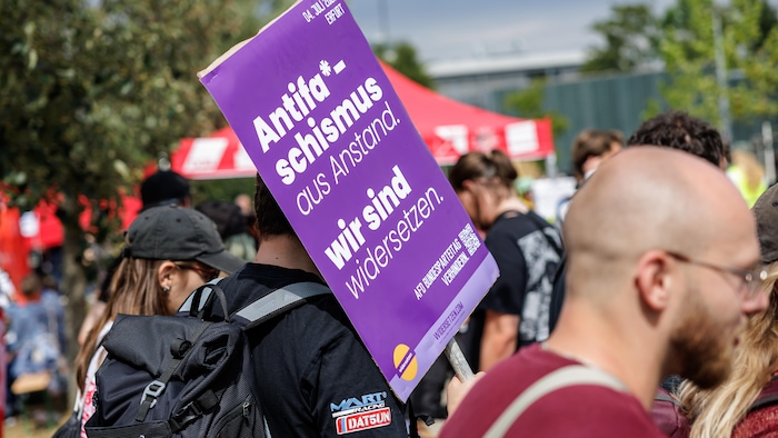 Des manifestants brandissent des pancartes.