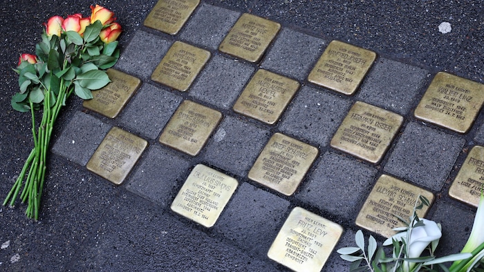 Des fleurs sont déposées à côté des plaques.