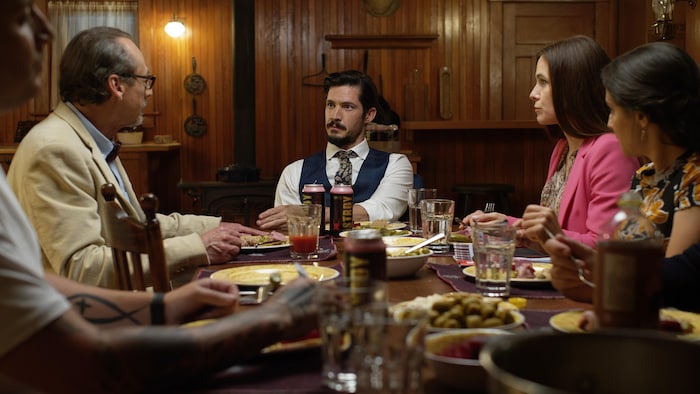 Les hommes et les femmes sont assis à une table et mangent.
