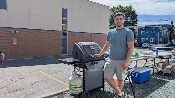 M. Duret pose devant un barbecue.