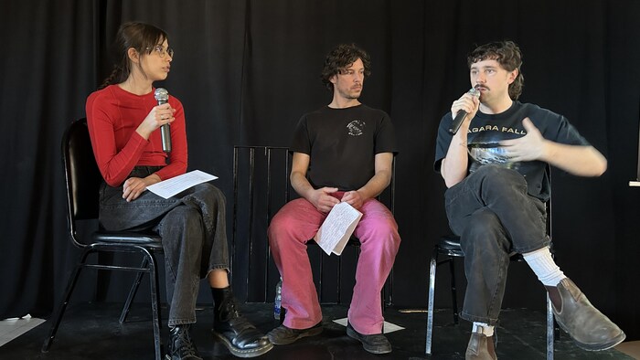 3 personnes discutent de logement devant plusieurs personnes.