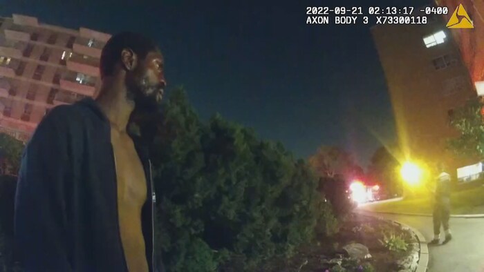 Un individu légèrement vêtu dans la nuit attend son transport à l'hôpital.