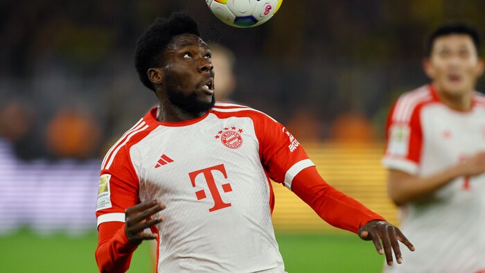 Alphonso Davies s'apprête à frapper le ballon avec sa tête.