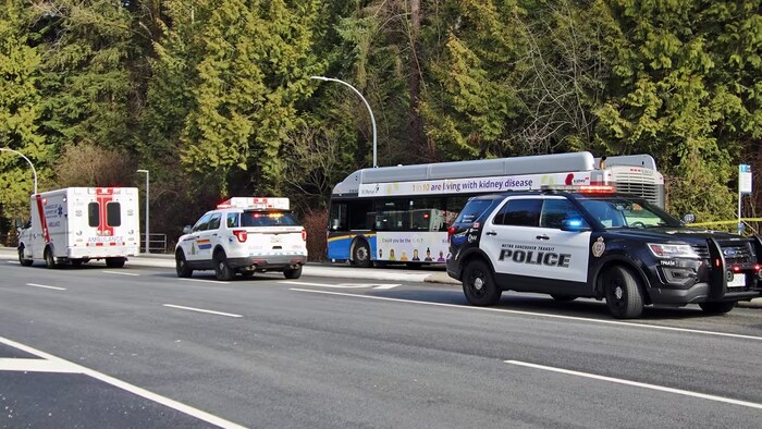 Un autobus, deux voitures de police et une ambulance.