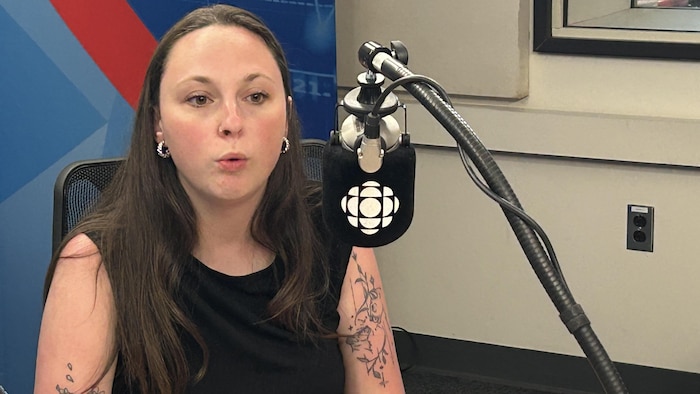 Une femme parle au micro dans le cadre d'une émission de radio.