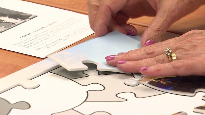 Un puzzle est assemblé au centre d'aide pour personnes atteintes de la maladie d'Alzheimer à Surrey en Colombie-Britannique.