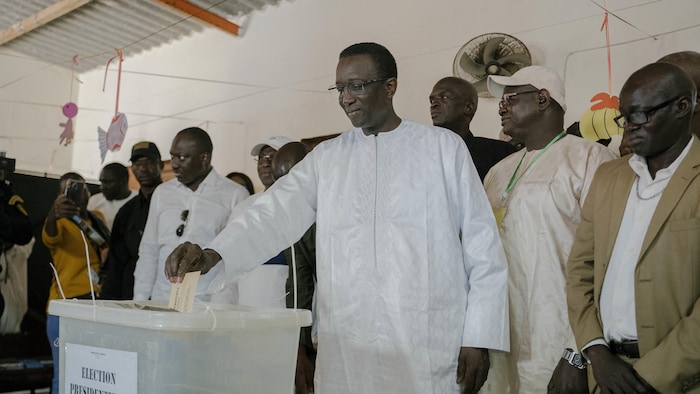 Amadou Ba place son bulletin de vote dans une urne.