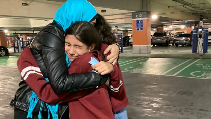 Amal Battrawi hugs her daughters at Toronto airport.