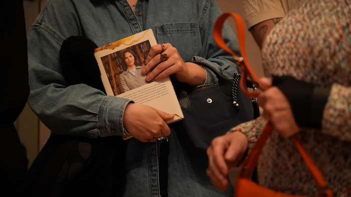 Des gens tiennent le livre « Free », d'Amanda Knox, lors de son passage à Vancouver, le 2 juin 2025.