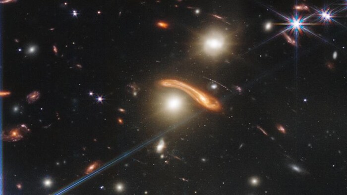 Gros plan sur une galaxie lointaine entourée de deux galaxies de l'amas SMACS 0723. 