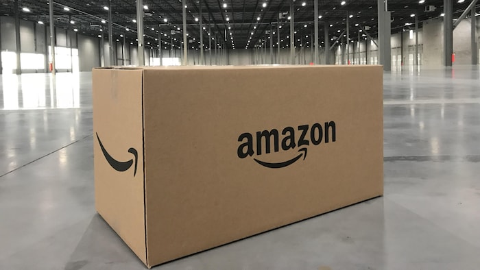 Une boîte portant le logo d'Amazon posée sur le sol d'un entrepôt vide.