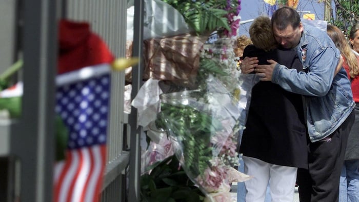 Un homme et une femme devant l'ambassade des États-Unis à Ottawa.