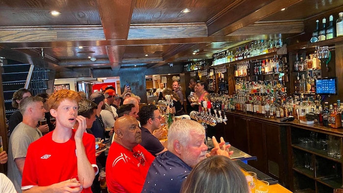 Une foule assise dans un bar.