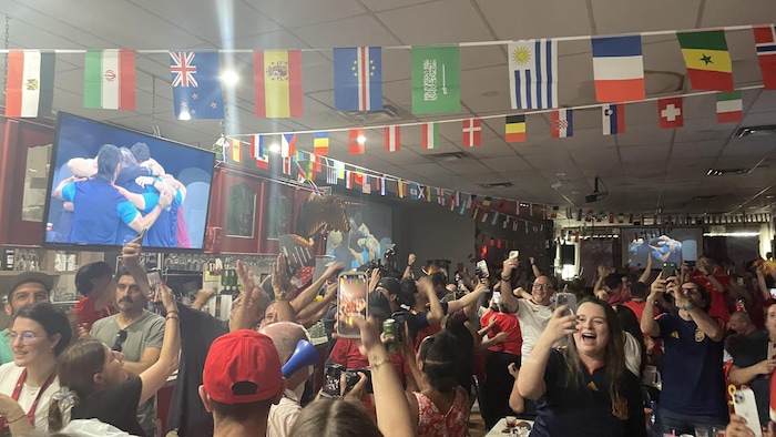 Une foule en liesse dans un bar.