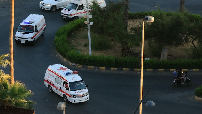 Trois ambulances arrivent devant un hôpital.