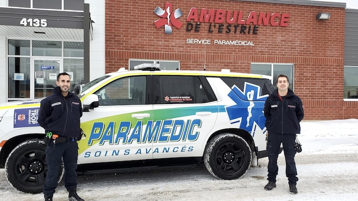 Deux ambulanciers devant leur véhicule.