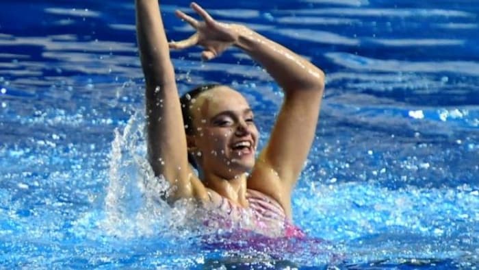Une adolescente qui fait de la nage artistique.