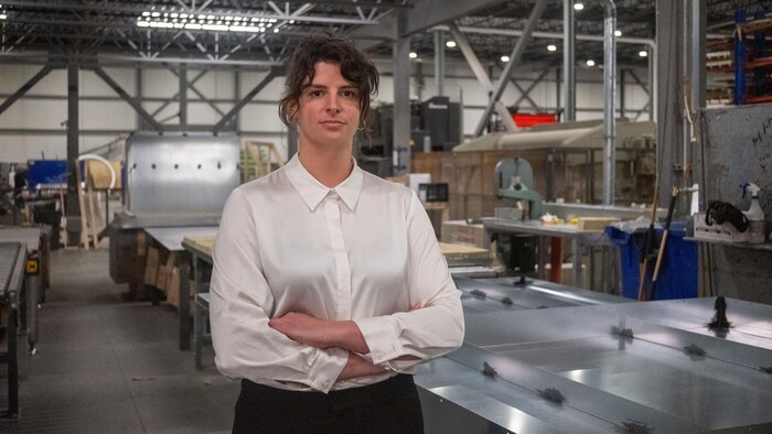 Amélie Poirier-Borduas, debout dans l'usine, les bras croisés.
