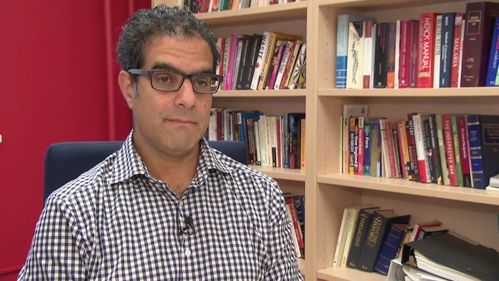 Amir Attaran en entrevue dans un bureau.