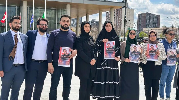 La famille et les amis de Mohammad Hassan Haidar brandissent des pancartes en hommage au Canadien tué.