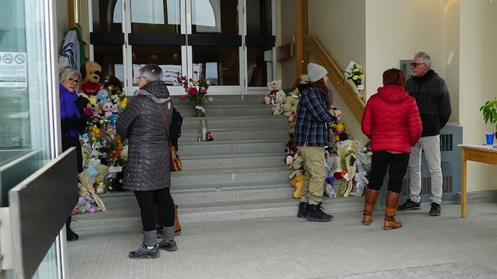 Des personnes parlent devant les marches à l'entrée de l'église.