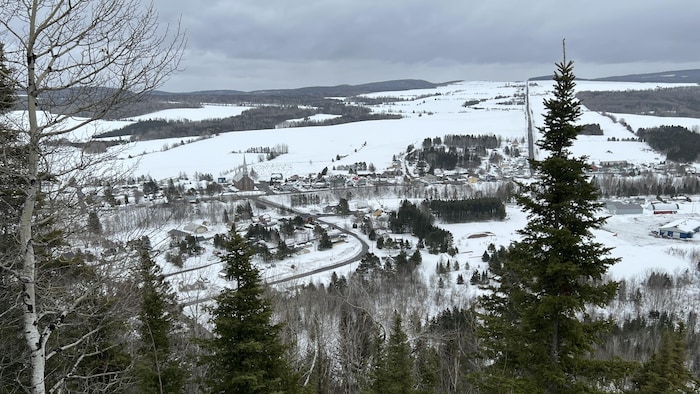 Vue aérienne de la rue principale, des habitations et des champs en hiver.