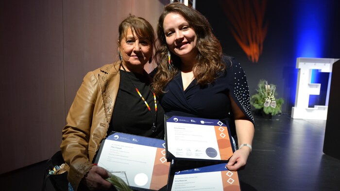 Deux femmes posent avec leurs diplômes.
