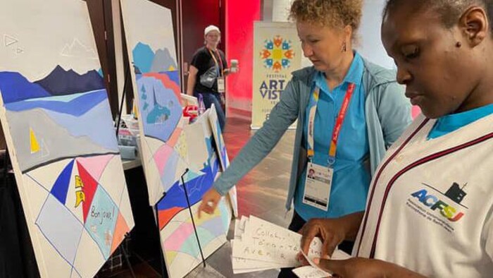 L'artiste visuelle Anastasia Tiller (à gauche) participe à la création de la murale en marge des Jeux du Canada 2025 au palais des congrès de Saint-Jean, à Terre-Neuve-et-Labrador, en août dernier.