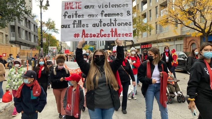 Anca Dura levant une pancarte en soutien aux femmes autochtones.