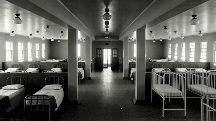 Un dortoir rempli de lits et de berceaux