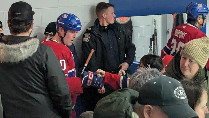 Éric Bélanger tape du poing avec un jeune garçon.