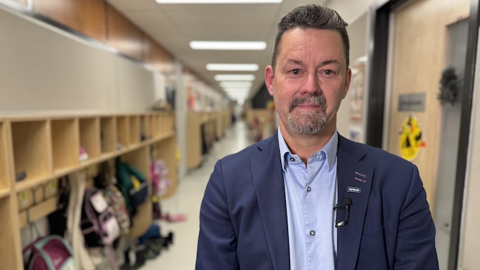Le président de l'Association québécoise du personnel de direction des écoles, André Bernier, prend la pose dans un corridor d'une école de Québec.