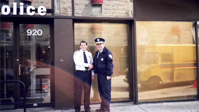 André Durocher et Jacques Duchesneau se serrent la main en souriant à la caméra.