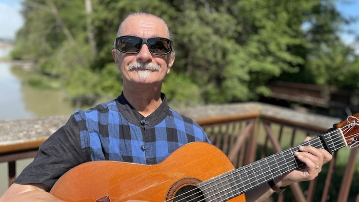 Photographie du musicien André Thibault jouant de la guitare.