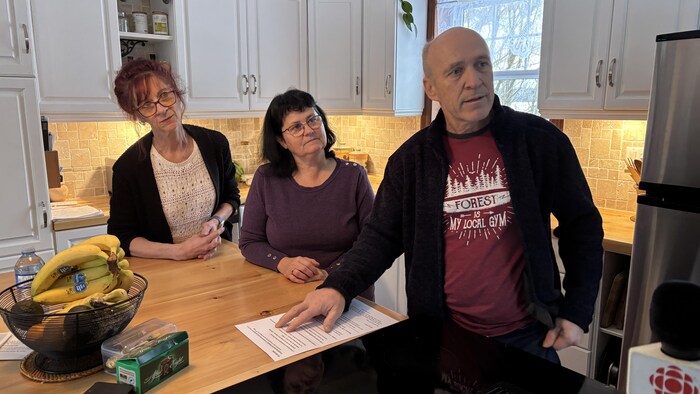 André Veillette et d'autres citoyens dans la cuisine d'une maison.