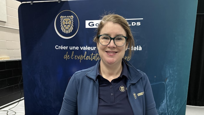 Andréanne Boisvert devant un panneau annonçant les valeurs de l'entreprise Gold Fields.