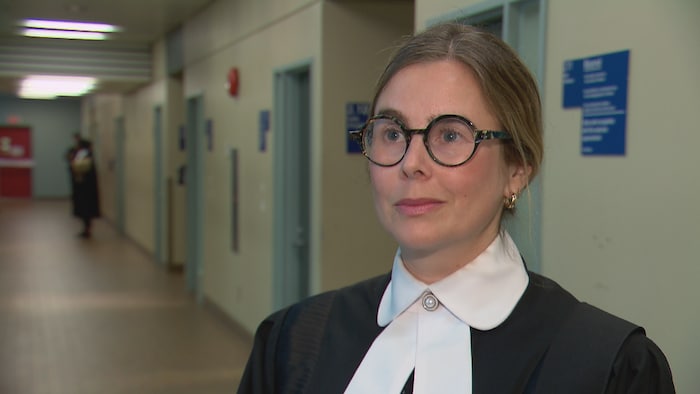 L'avocate porte des lunettes en entrevue.